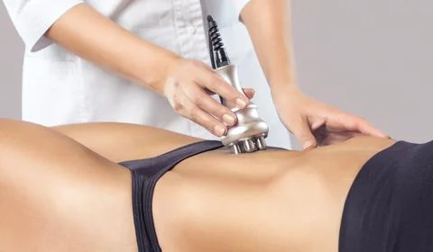 The doctor does the Rf lifting procedure on the stomach and hips of a woman i Stock Photos