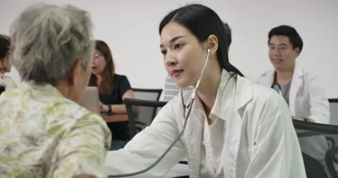 Doctor doing basic health care clinics to senior patient at volunteer center.  Stock Footage 152996210