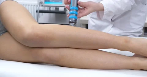 The Doctor doing Shock Wave therapy on Feet for a Sport Fit Girl in Modern Stock Footage 134158927