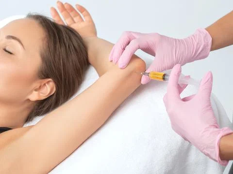 Doctor doing stem cell therapy on a patient's elbow after the injury. Treatin Stock Photos