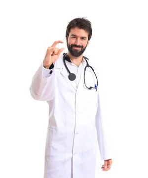 Doctor doing tiny sign over white background Stock Photos