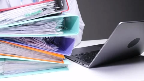 Doctor engaging with a large stack of patient files and documentation Stock Footage 324767922