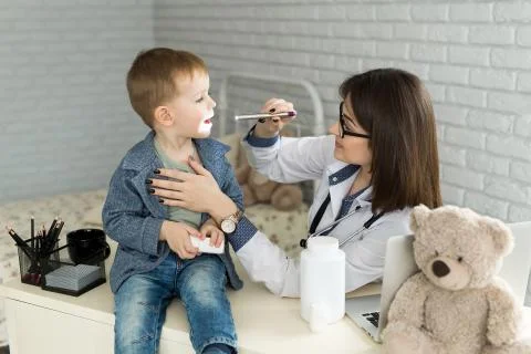 Doctor examine child's throat. Boy at pediatrician office Stock Photos