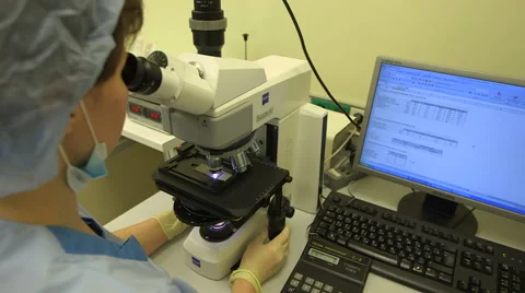 Doctor examines the cells under a microscope Stock Footage 40971993
