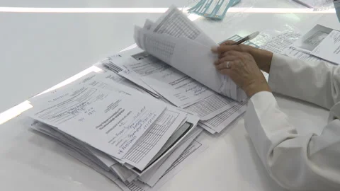 The doctor examines the documents. Looks at the patients profile.  動画素材 168535845