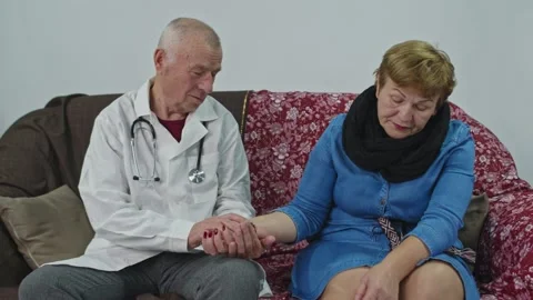 The doctor examines an old woman patient and chechs the pulse. Stock Footage