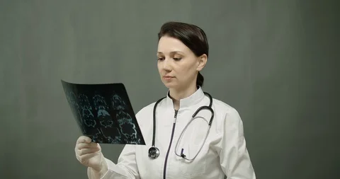 The doctor examines the tomogram of the head and makes a diagnosis . Video Stock Footage 129675262