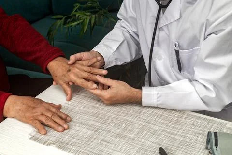 Doctor examining the hand of an elderly man with osteoarthritis Stock Photos