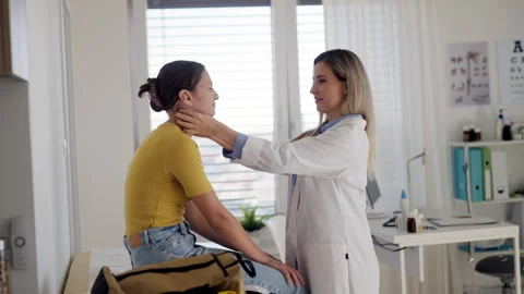 Doctor examining lymp nodes on neck of the teenage girl. Palpation of lymph Stock Footage 259897128