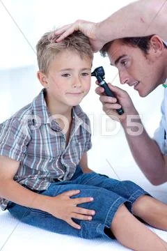 Doctor examining a patient' s ears with a otoscope Stock Photos