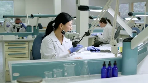 Doctor examining samples through a microscope Stock Footage 77078809