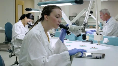 Doctor examining samples through a microscope 動画素材 77097635