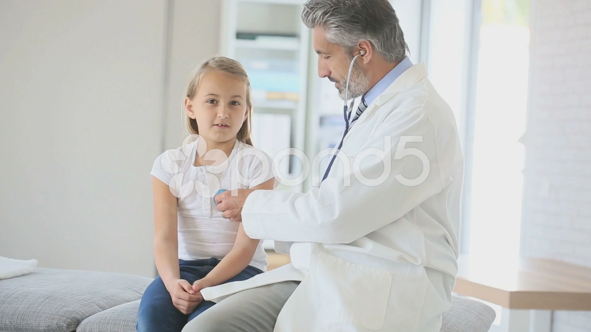 Doctor examining young girl with stethos... | Stock Video | Pond5