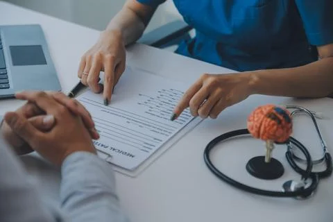 Doctor explaining brain functions to patient on model in office. Stock Photos