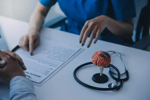Doctor explaining brain functions to patient on model in office. Stock Photos
