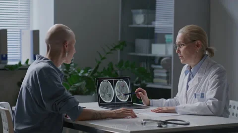 Doctor Explaining Brain MRI Scan Results on Laptop to Bald Oncology Patient Stock Footage 340996352