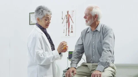 Doctor explaining medication to elderly male patient Stock-Footage 80131240