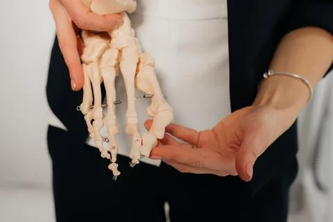 Doctor explaining operation to foot on bone model Stock Photos