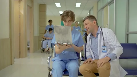 Doctor explaining patient diagnosis to one of female medical student for advice. Stock Footage 189907235