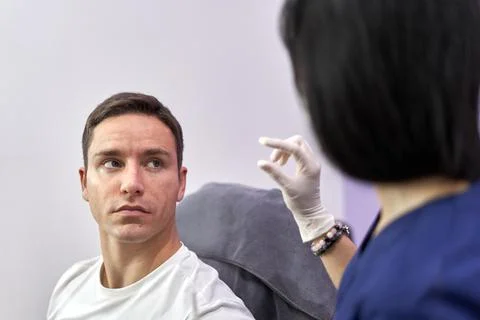 Doctor explaining to a patient while gesturing at a unit of measure Stock Photos
