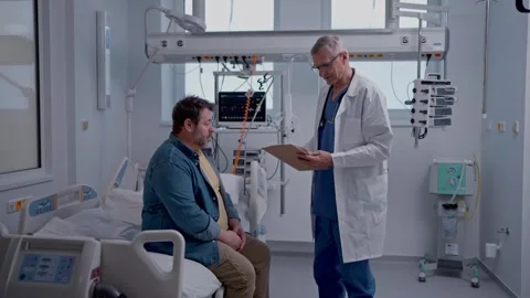 Doctor explaining the risks of leaving the hospital early as the patient Stock-Footage 311240014