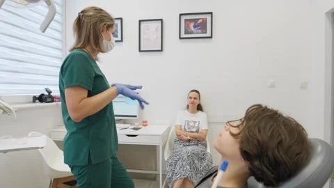 Doctor explaining the treatment plan to a young boy and his mother Video stock 318346128