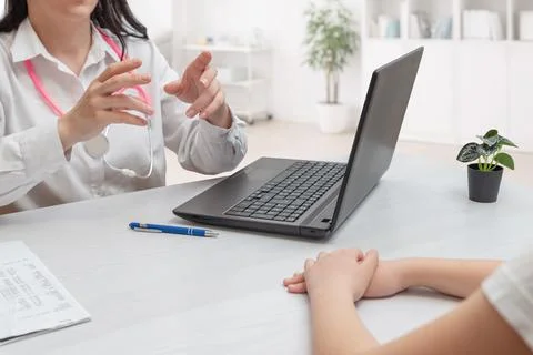 Doctor explaining treatment using laptop during consultation representing h.. Stock Photos
