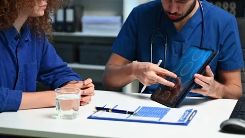 Doctor explains brain scan to patient using a tablet in modern clinic. Idea.. Video stock 312383371