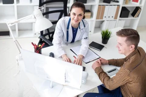 The doctor explains the problem to the patient on the computer. Stock Photos