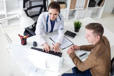 The doctor explains the problem to the patient on the computer. Stock Photos
