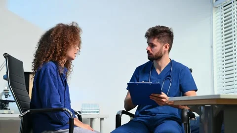 Doctor explains spinal anatomy with model and X-ray to patient during consu.. Stock Footage 312386744