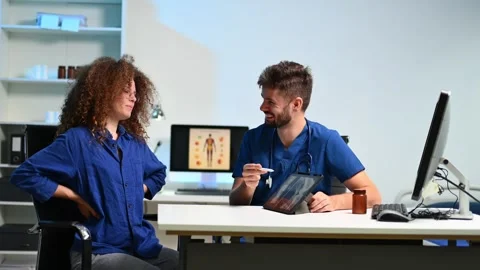 Doctor explains spinal X-ray on tablet to patient with lower back pain. Con.. Stock Footage 312383549