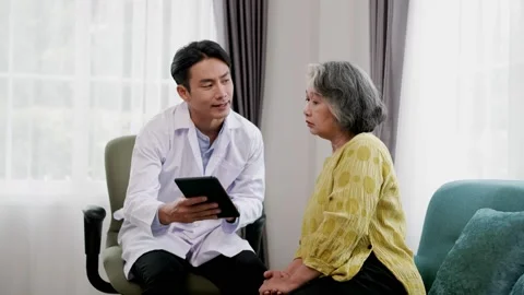 Doctor explains symptoms from tablet to elderly female patient. Stock Footage 153069270