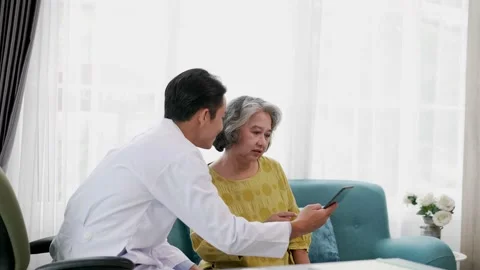 Doctor explains symptoms from tablet to elderly female patient. Stock Footage 153069324