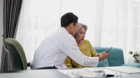 Doctor explains symptoms from tablet to elderly female patient. Stock Footage 153069344