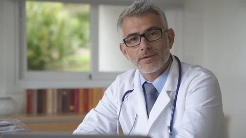 Doctor with eyeglasses talking to camera Stock Footage