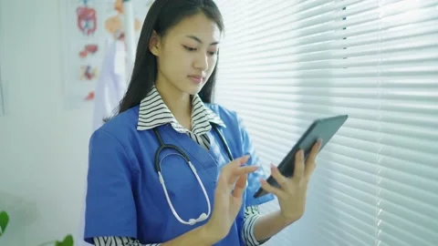 Doctor female using digital tablet computer app standing in office. Видео 149950807