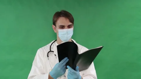 Doctor flips through a folder with medical records, isolated on a green screen. Stock Footage 162678436