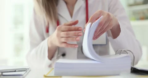 Doctor flips through stack of documents in clinic Stock Footage 275823811