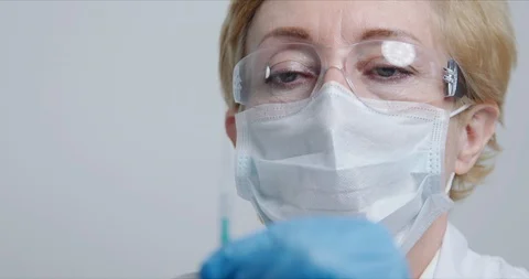 Doctor in front of the camera preparing syringe with avaccine for injection Stock Footage 125898412
