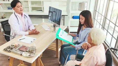 A doctor general practitioner consults an elderly patient in wheelchair. Stock Footage 303483009