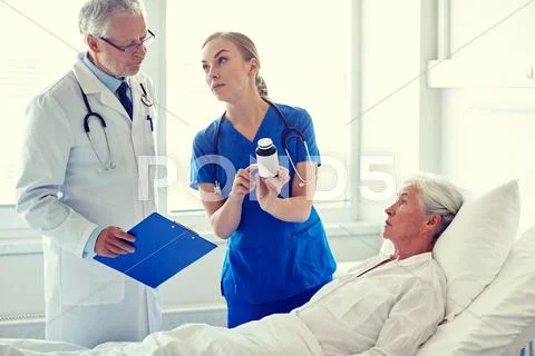 Doctor giving medicine to senior woman at hospital Stock Photos