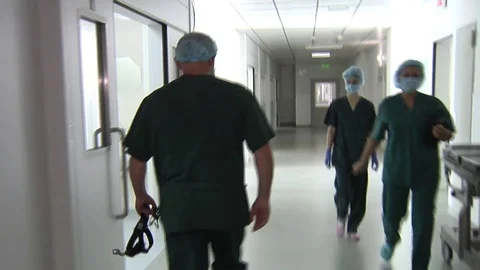 Doctor going to the operating room through long hospital hall Stock Footage 72496176