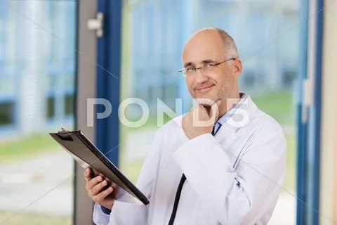Doctor with hand on chin Stock Photos