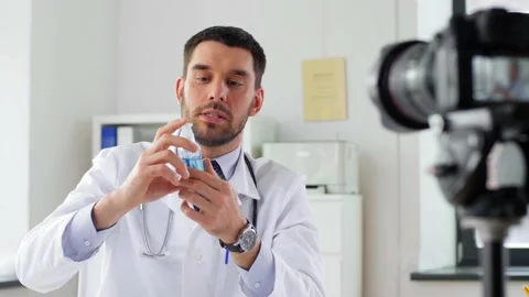 Doctor with hand sanitizer recording video blog Stock Footage