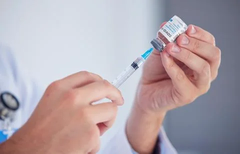 Doctor, hands and covid vaccine with syringe for cure, illness or flu shot at Stock Photos