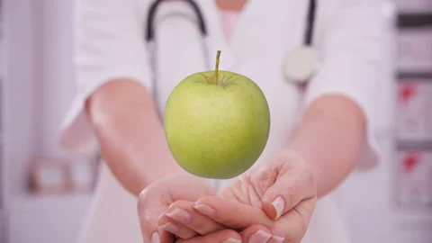 Doctor hands presenting a virtual apple over palms Video stock 141953497