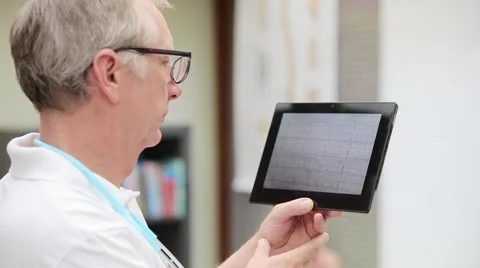 Doctor having a look at ecg on tablet PC Stock Footage 61028852