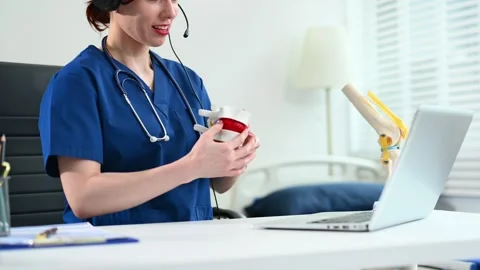 Doctor with headset explains joint anatomy using knee model in online consu.. Stock Footage 316459448