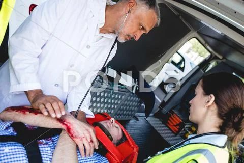 Doctor Healing Injured Man In Ambulance Car
